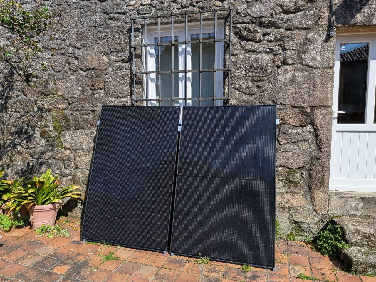 Los dos paneles JASOLAR 450W apoyados contra la pared de piedra
